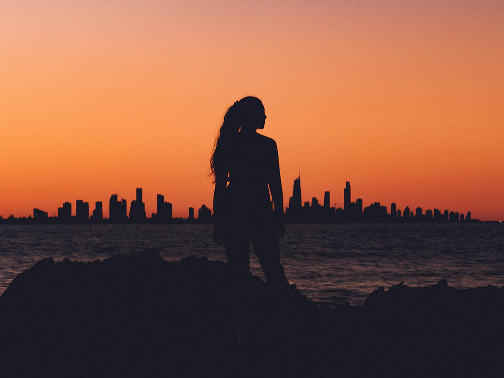 silhouette woman city skyline sunset
